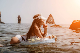 女人夏天海快乐女人游泳充气甜甜圈海滩夏天阳光明媚的一天包围火山山夏天假期概念