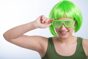 快乐的年轻的女人绿色假发有趣的眼镜庆祝帕特里克的一天白色背景