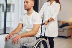 医疗工人女人帮助禁用男人。轮椅首页