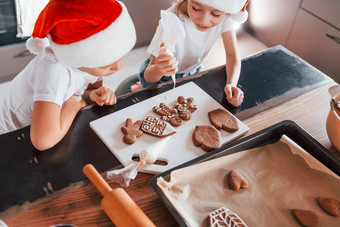 圣诞老人帽子男孩女孩准备圣诞节饼干厨房