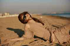 红发女人黑暗太阳镜sand-colored衣服谎言海滩