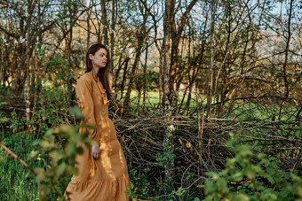 美丽的纤细的女人长头发走阴影树穿着长橙色衣服享受天气周末主题隐私自然