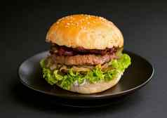 特写镜头美味的新鲜的自制的汉堡生菜洋葱番茄黑暗背景