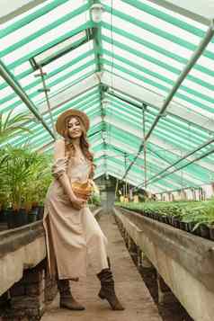 美丽的年轻的女人需要护理植物温室概念园艺环保生活方式