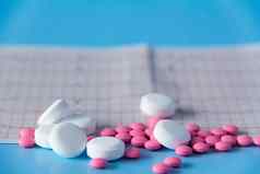 大一些粉红色的白色药物谎言心电图心蓝色的背景概念健康的生活方式及时的医疗检查