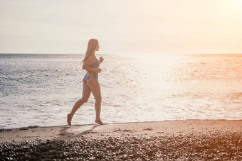 运行女人夏天海滩女人慢跑海滩日出软光早....太阳照明沙子海唤起感觉更<strong>新能源</strong>健康