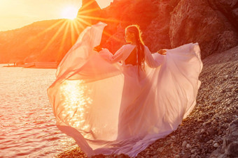 神秘的女人轮廓长头发走海滩海洋水海美丽的少女风听波抛出长白色衣服神圣的日落艺术照片回来脸