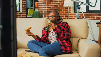 快乐的女人吃片披萨看电影