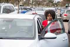 非洲美国女人红色的外套打开门白色车
