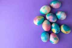 复活节作文色彩斑斓的鸡蛋购物车木兔子春天花紫色的背景复制空间