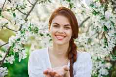 肖像快乐笑红发女人开花树花园