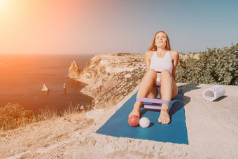 女人海普拉提<strong>运动快乐</strong>中间岁的女人练习健身瑜伽席橡胶磁带按摩球辊海微笑活跃的女<strong>享</strong>受健康的生活方式