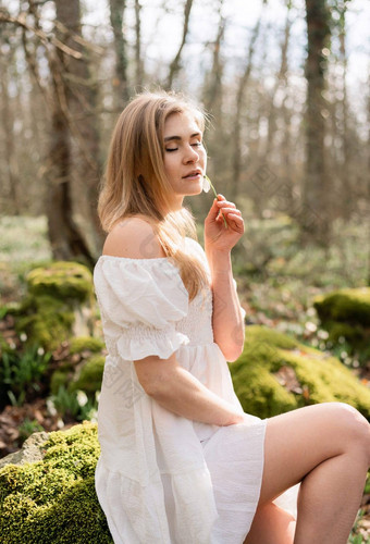 雪花莲雪花属金发女郎女孩白色衣服坐在草地雪花莲春天森林