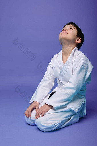 迷人的愉快的高加索人男孩白色和服练习东方武术艺术孤立的紫罗兰色的背景复制空间文本