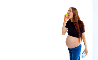 怀孕了女人提出苹果肚子复制空间美丽的准夫人新鲜的零食灰色的工作室背景健康的营养怀孕概念复制空间