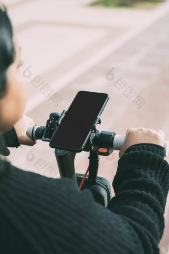关闭视图聪明的电话年轻的拉丁美洲女人开车电踏板车