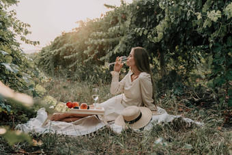 女人野餐葡萄园快乐女人玻璃酒野餐葡萄园酒品尝日落开放自然夏天浪漫的晚餐水果酒