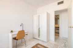 舒适的室内白色音调衣柜表格椅子开放通过浴室概念明亮的新鲜的室内公寓