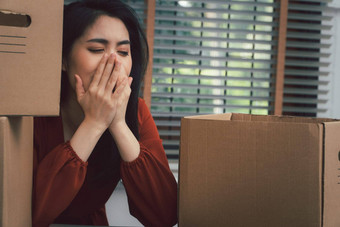 伤心亚洲女人包装物品纸板盒子哭桌子上办公室裁员失业概念影响经济经济低迷管理失败