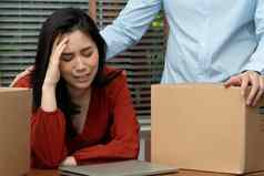 伤心亚洲女人包装物品纸板盒子哭桌子上办公室裁员失业概念影响经济经济低迷管理失败