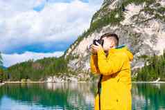 年轻的男人。摄影师持有相机采取照片阿尔卑斯山脉