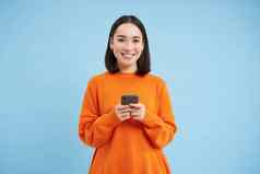 女孩智能手机手微笑移动应用程序电话发送消息订单在线蓝色的背景