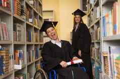 快乐年轻的女人女人轮椅研究生礼服文凭手图书馆包容教育