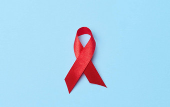 丝绸红色的丝带形式弓蓝色的背景象征战斗艾滋病标志团结支持
