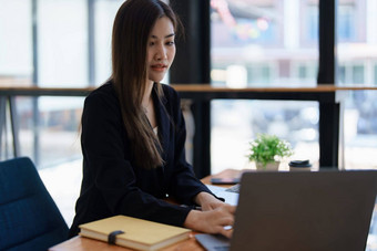 年轻的亚洲女商人经理律师公司员工持有会计记账文档检查金融数据市场营销报告工作办公室移动PC文书工作管理
