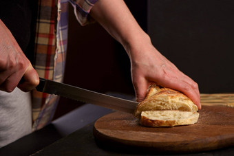 粮食面包把厨房木板老板持有刀减少健康的吃传统的面包店概念前面viev新鲜的面包表格特写镜头新鲜的面包厨房表格
