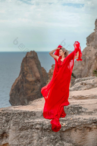 女人红色的丝绸衣服站海洋山背景衣服摇摆微风