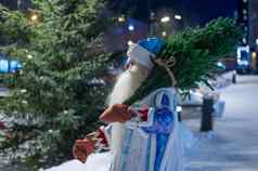 俄罗斯圣诞老人老人携带圣诞节树在户外