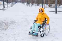 高加索人女人残疾的人游乐设施椅子公园冬天女孩走轮椅