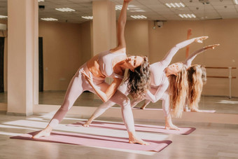 中间岁的运动女人健身教练粉红色的运动<strong>服</strong>装伸展运动普拉提<strong>瑜伽</strong>席工作室镜子女健身<strong>瑜伽</strong>健康的生活方式和谐