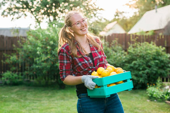 有机女农民持有盒子完整的新鲜的生产农场Copyspace快乐年轻的女人微笑相机站蔬菜花园成功的女农民收获蔬菜