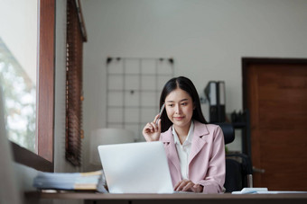 年轻的亚洲女商人经理律师公司员工持有会计记账文档检查金融数据市场营销报告工作办公室移动PC文书工作管理