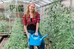 女人花园浇水水域植物绿色西红柿园艺温室概念