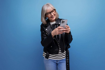 精力充沛的现代中间岁的女人灰色的头发聊天互联网智能<strong>手机</strong>明亮的背景