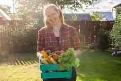 女农民携带盒子选蔬菜花园收获农业产品在线销售
