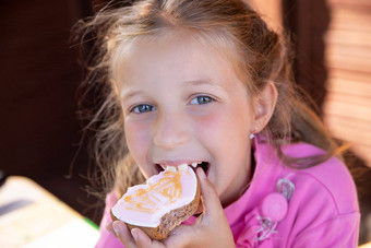 微笑青少年女孩吃燕麦片饼干模糊背景快乐金发碧眼的女孩吃姜饼首页