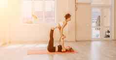 中间岁的女人黑色的头发健身教练紧身裤上衣伸展运动普拉提瑜伽席镜子女健身瑜伽例程概念健康的生活方式