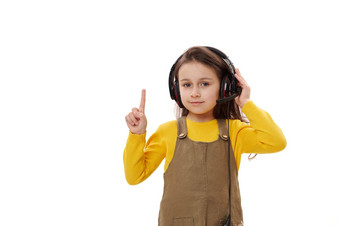 可爱的微笑女孩穿耳机在线教育距离学习指出手指复制空间