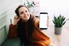 快乐年轻的女人持有移动电话手显示手机显示展示大白色空白细胞显示模板模拟智能手机模型屏幕数字应用程序促销广告