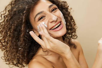 女人美脸特写镜头应用泡沫洗净化皮肤手指手指甲头发健康头发干燥机风格卷曲的非洲式发型头发身体美护理概念