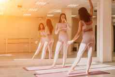 中间岁的运动女人健身教练粉红色的运动服装伸展运动普拉提瑜伽席工作室镜子女健身瑜伽健康的生活方式和谐