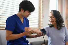 健康工人测量血压力中间年龄女人首页访问医疗保健首页健康护理服务