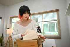 拍摄年轻的女小业务老板包装服装纸板盒子交付客户