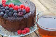 自制的巧克力蛋糕装饰黑色的红色的树莓玻璃板杯茶
