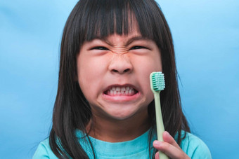 微笑可爱的女孩持有牙刷孤立的蓝色的背景可爱的孩子刷牙牙齿孩子<strong>培训</strong>口服卫生牙衰变预防<strong>牙科</strong>护理概念