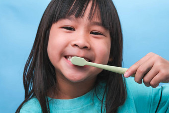 微笑可爱的女孩持有牙刷孤立的蓝色的背景可爱的孩子刷牙牙齿孩子<strong>培训</strong>口服卫生牙衰变预防<strong>牙科</strong>护理概念